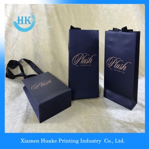 La cinta de lujo maneja las bolsas de papel de las compras del regalo con su propio logotipo 